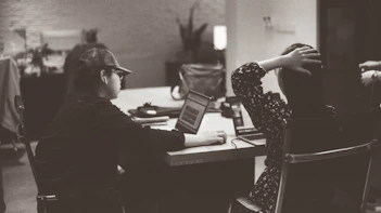 Two people are working at a table in an office.