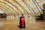 A person uses a floor scrubber inside a building.