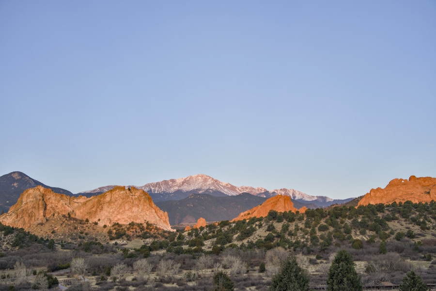 Mountains and rock formations are lit at dawn.