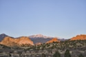 Mountains and rock formations are lit at dawn.