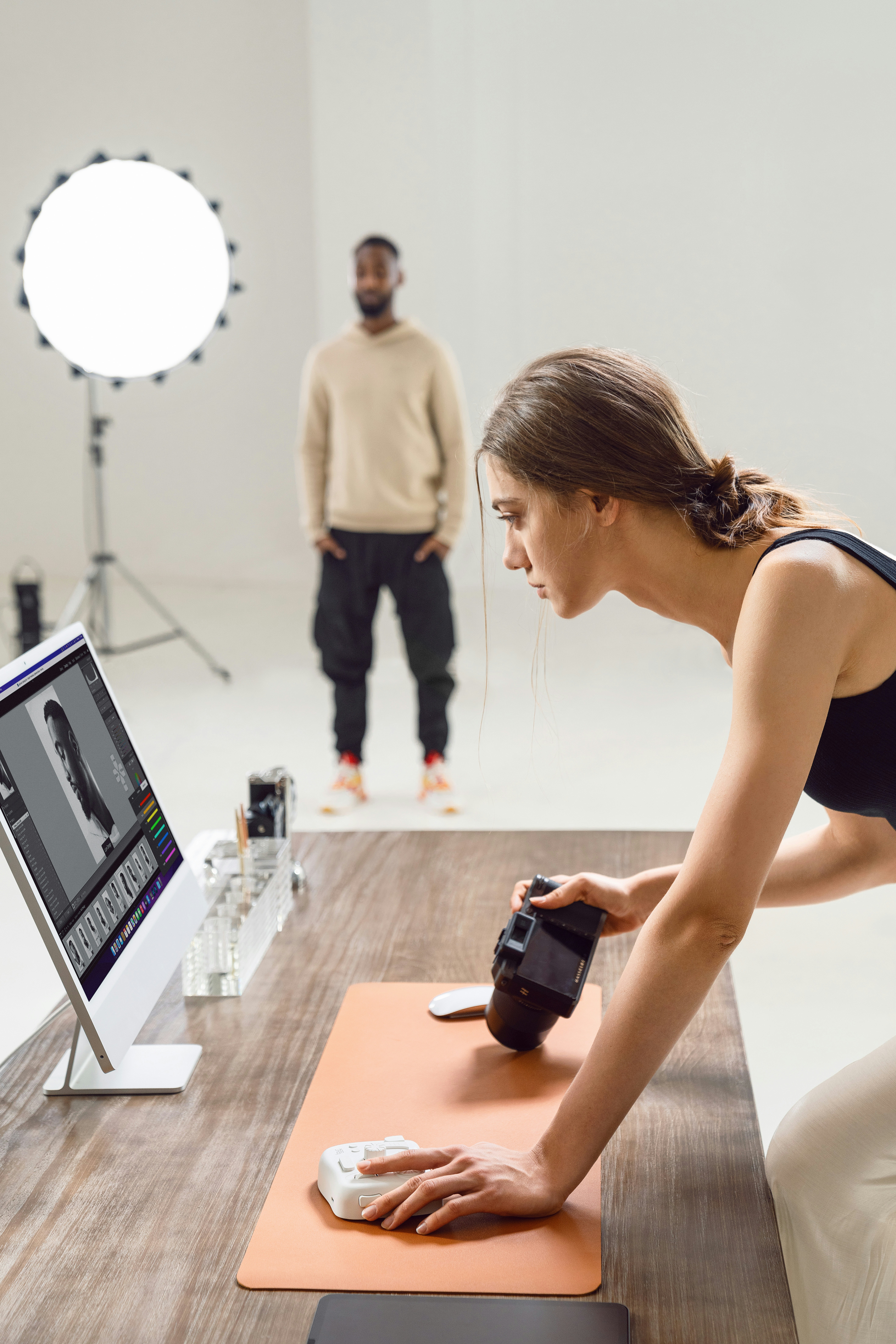 Photographer captures image with model and computer screen.