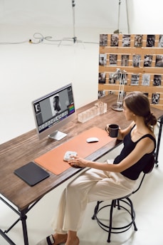 A woman edits photos at her desk.
