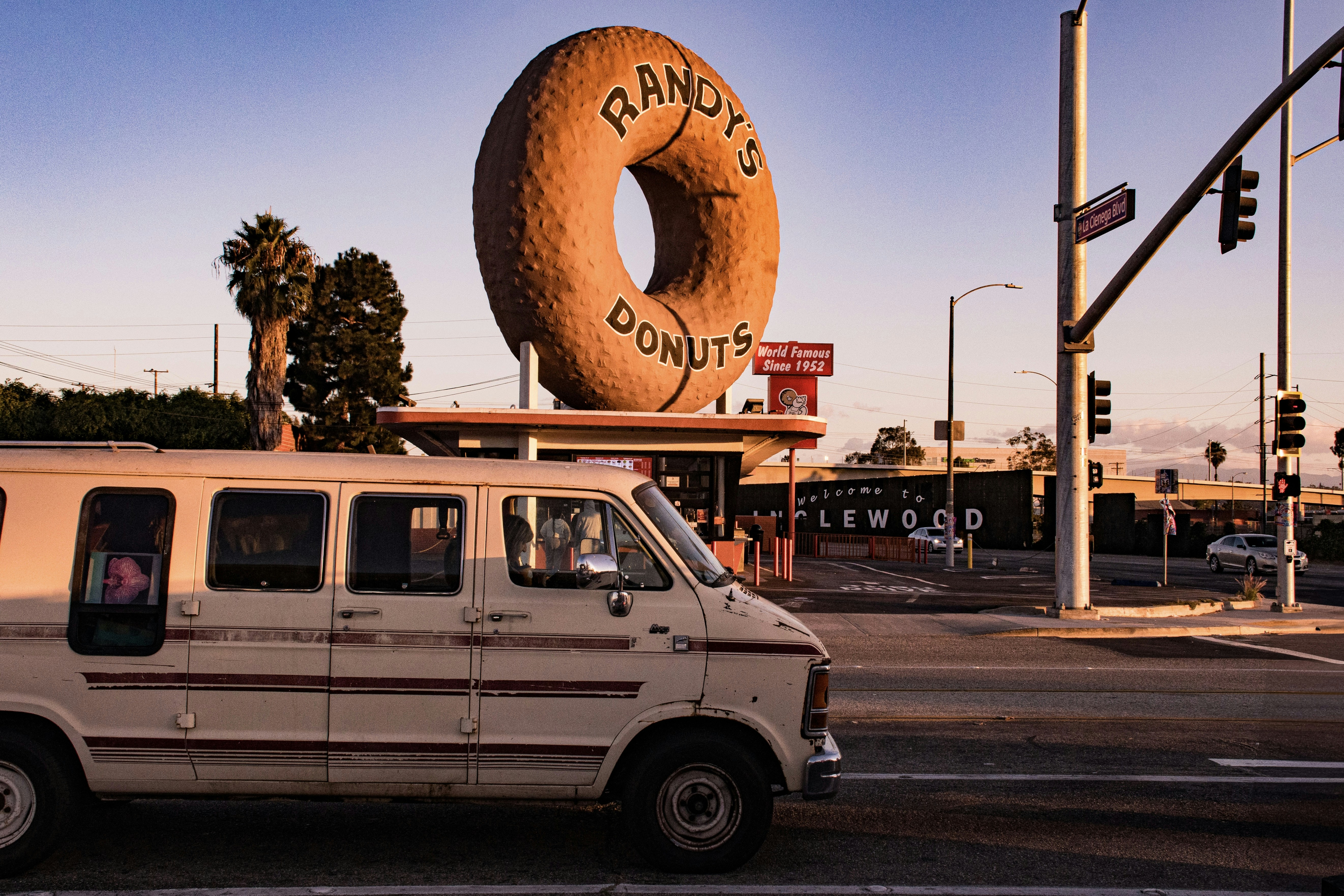 A van drives past the iconic randy's donuts.