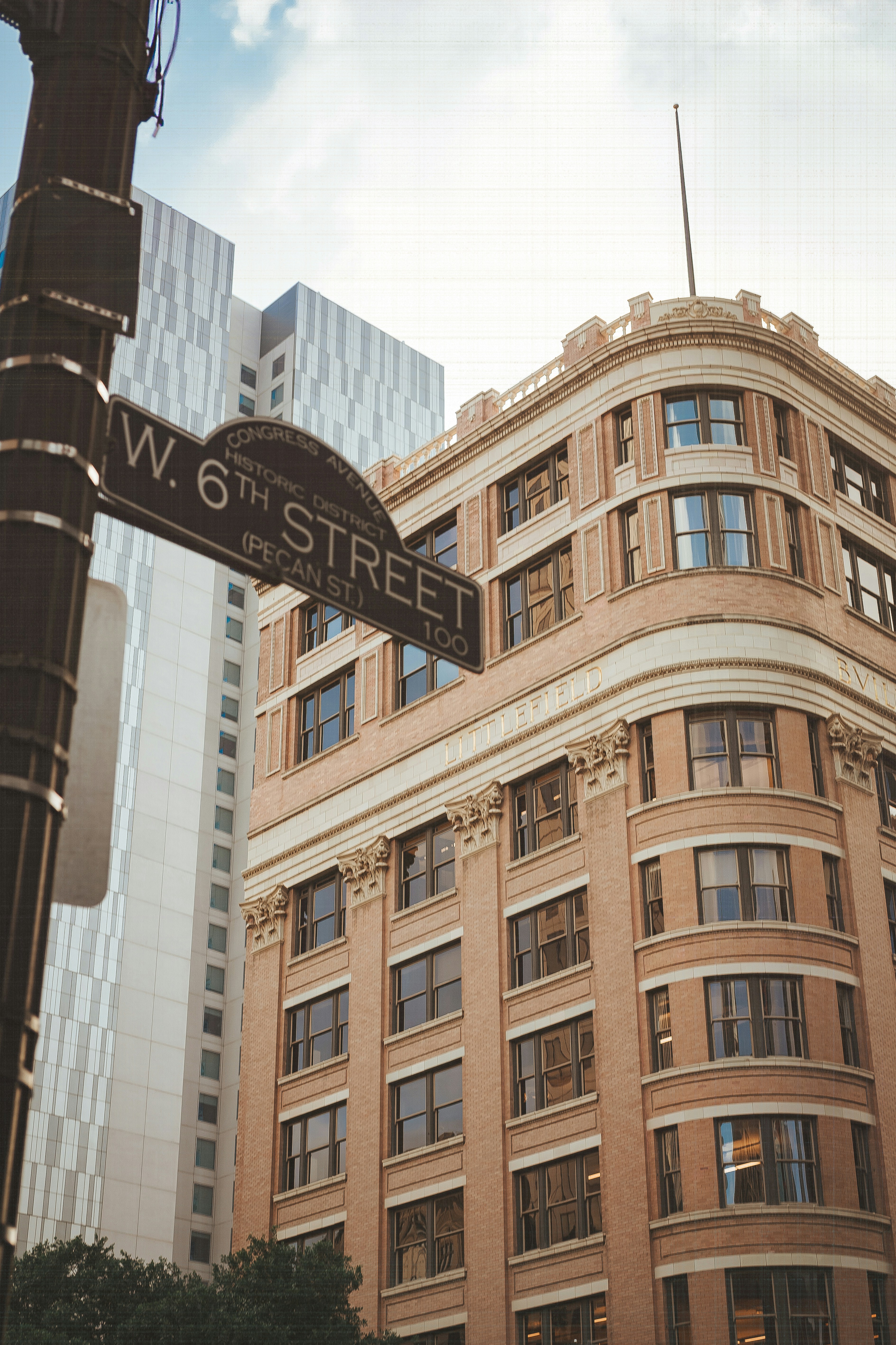 A street sign points towards a beautiful building.