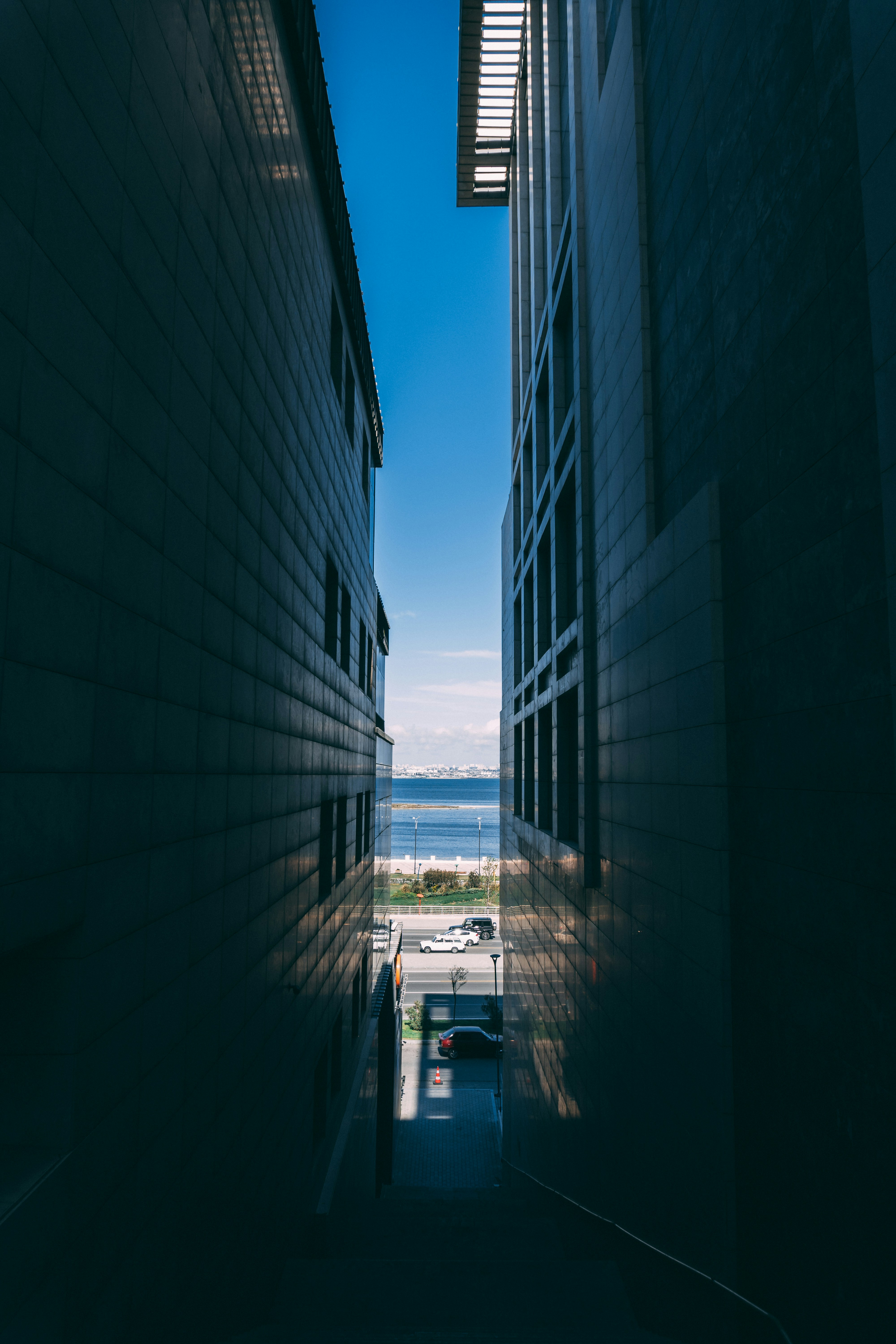 Buildings frame a view of the distant ocean.