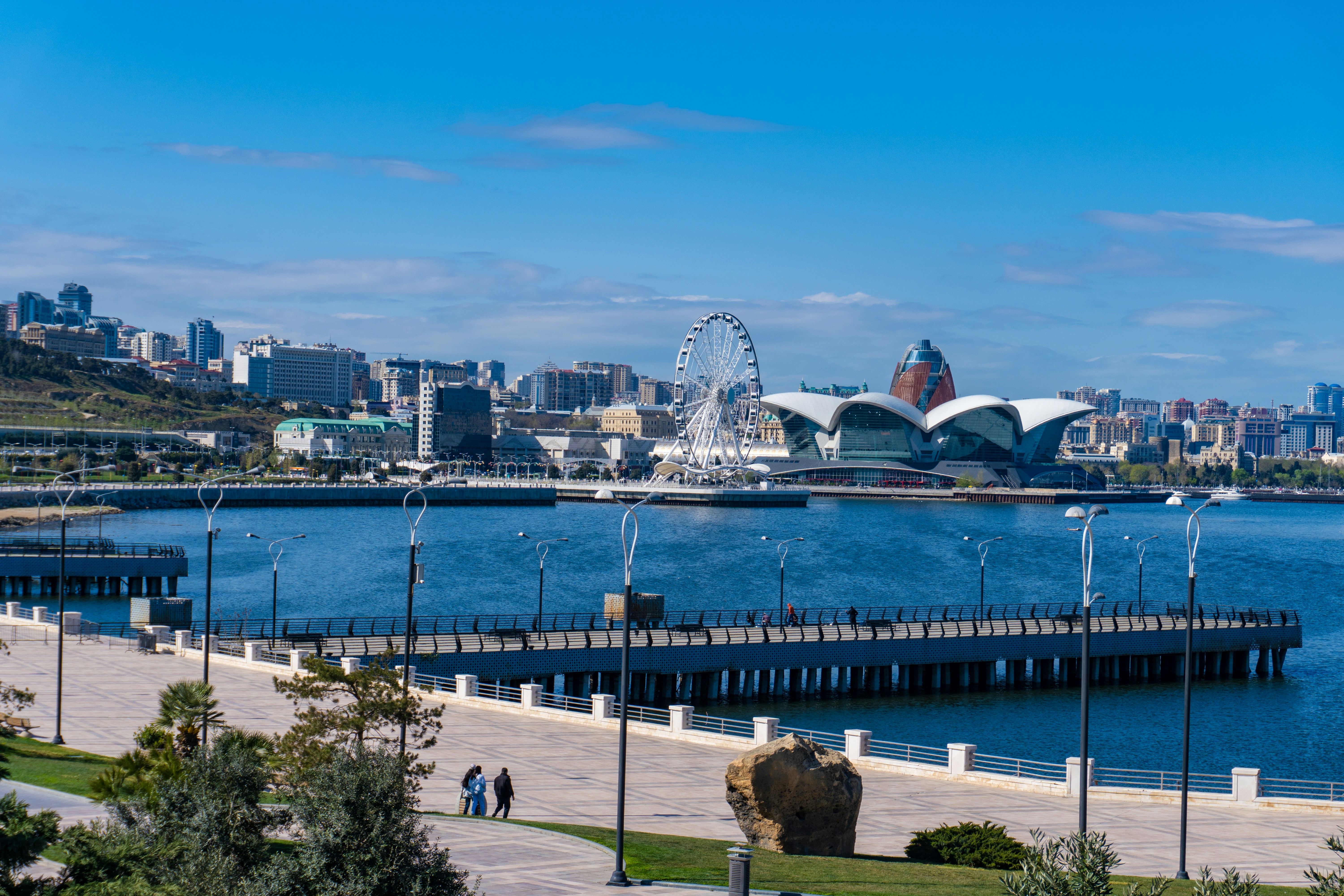 A coastal cityscape with a ferris wheel.