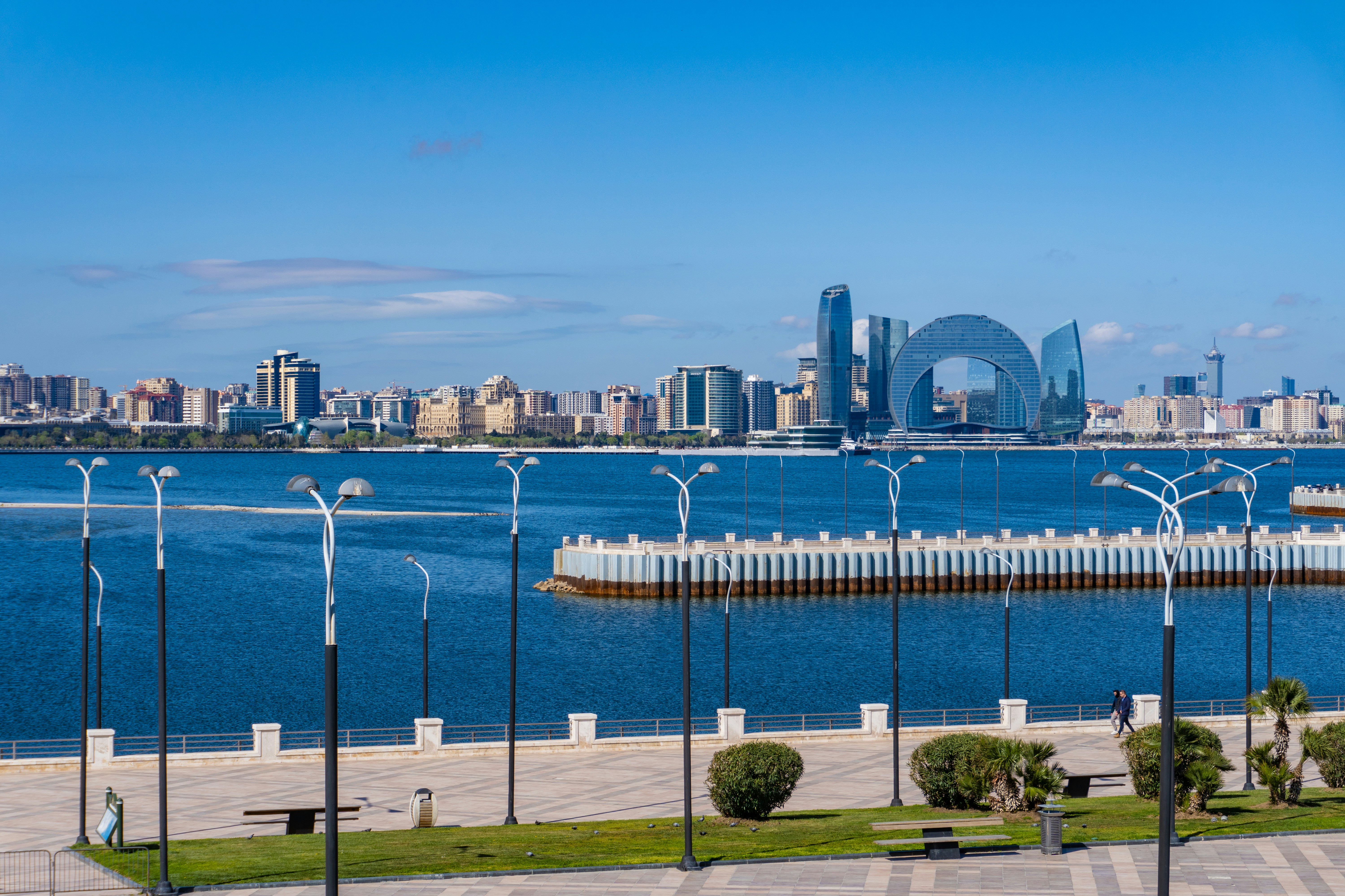 City skyline over a vast, blue sea.