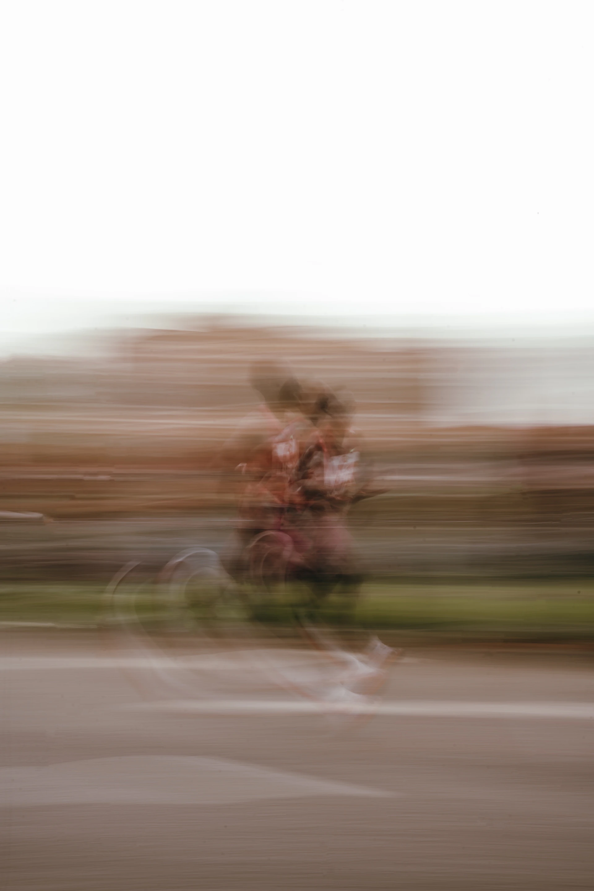 A blurred image of someone riding a bicycle.