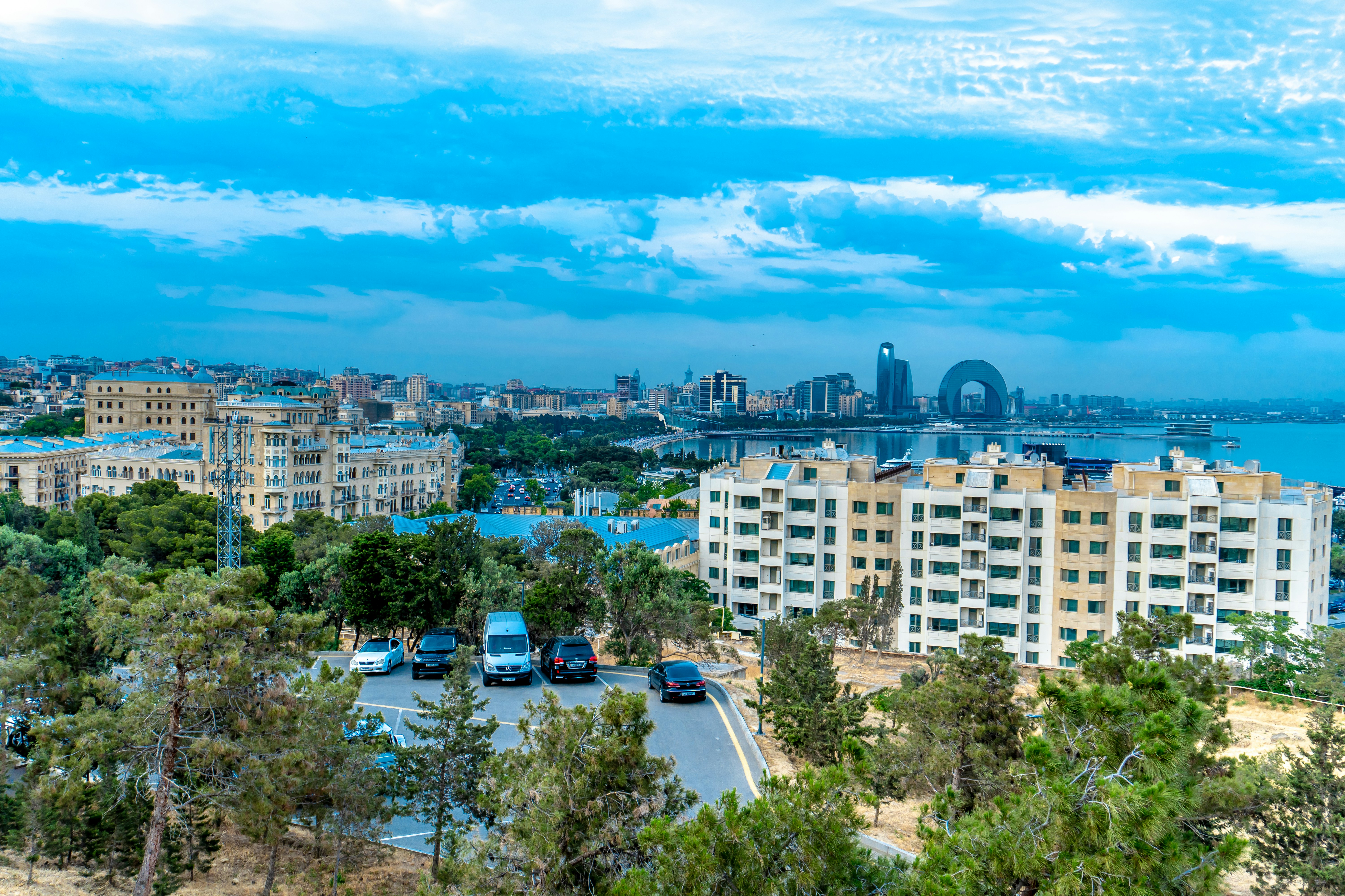 Cityscape view overlooking the coast under a blue sky.