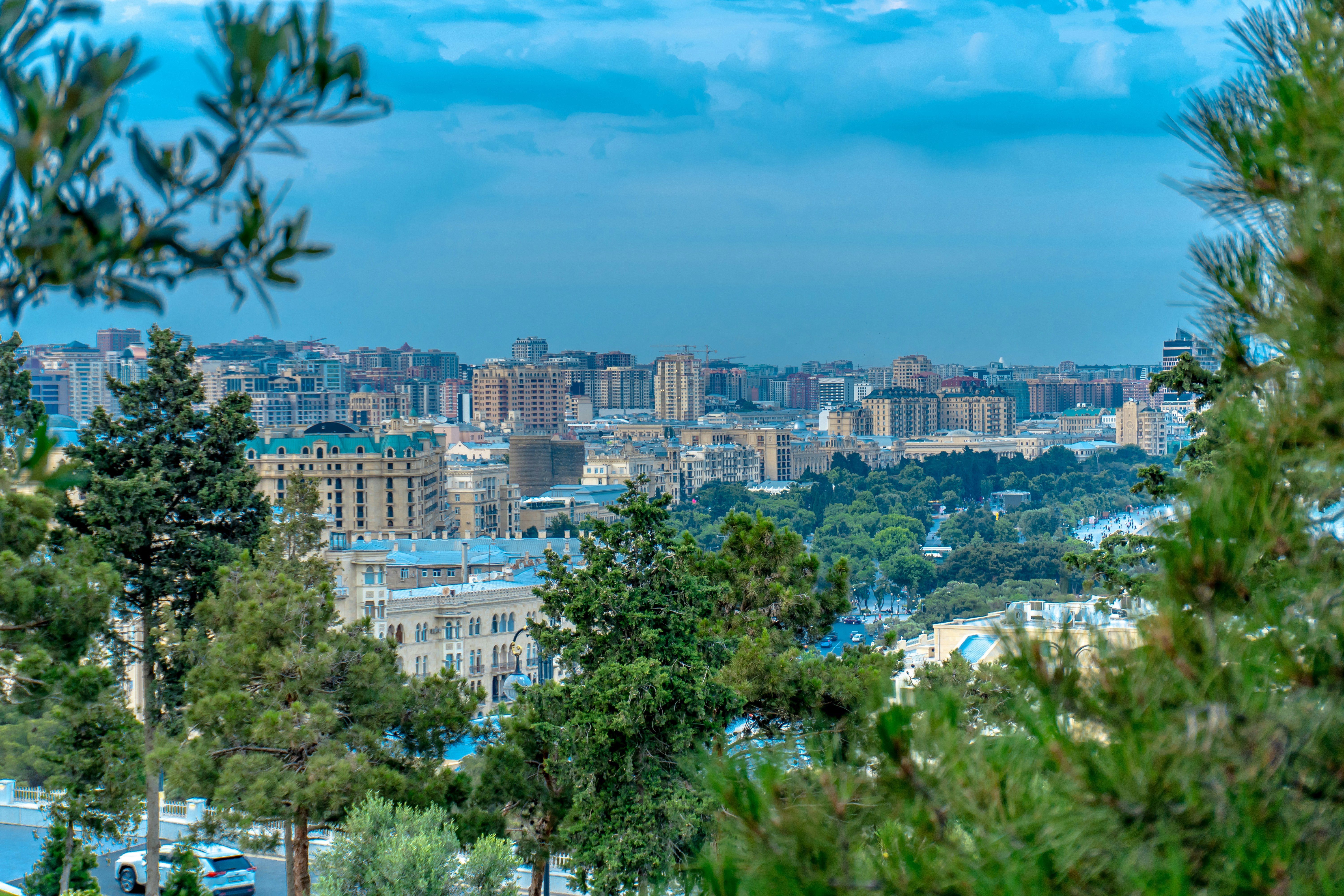 Cityscape of baku, azerbaijan is seen through trees.