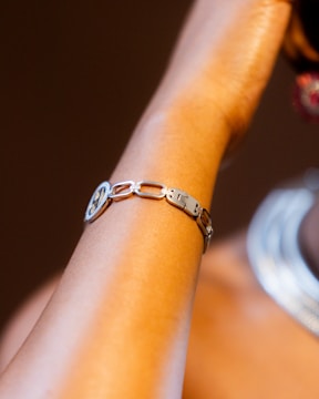 A silver bracelet adorns a person's wrist.