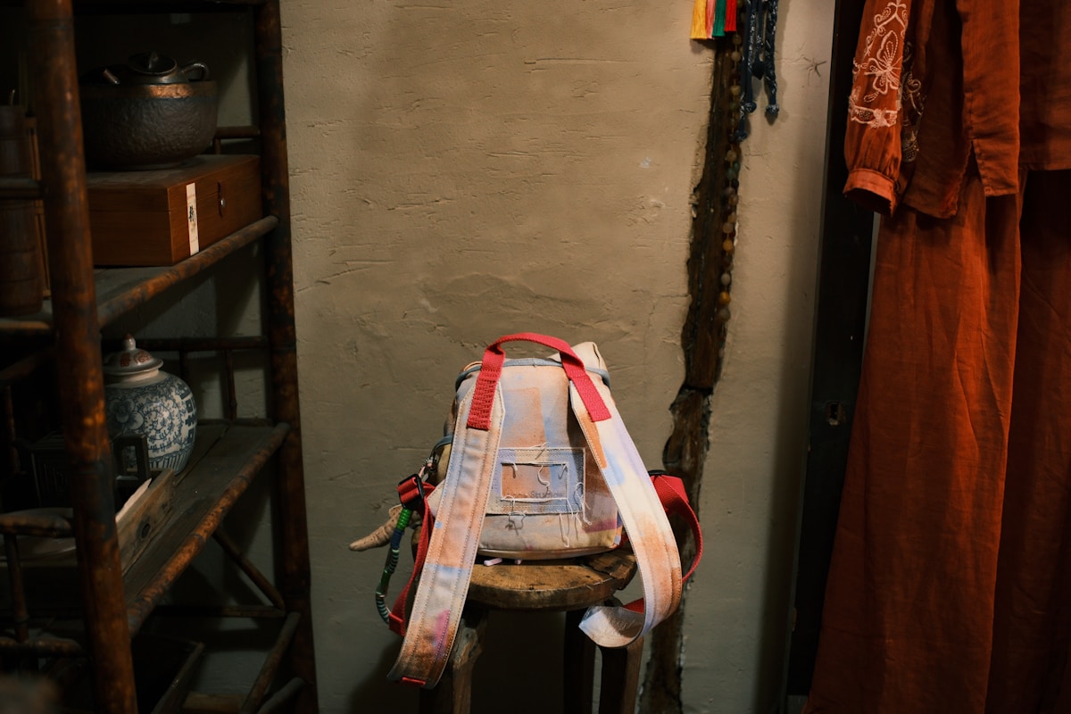 A backpack sits propped up against a wall.