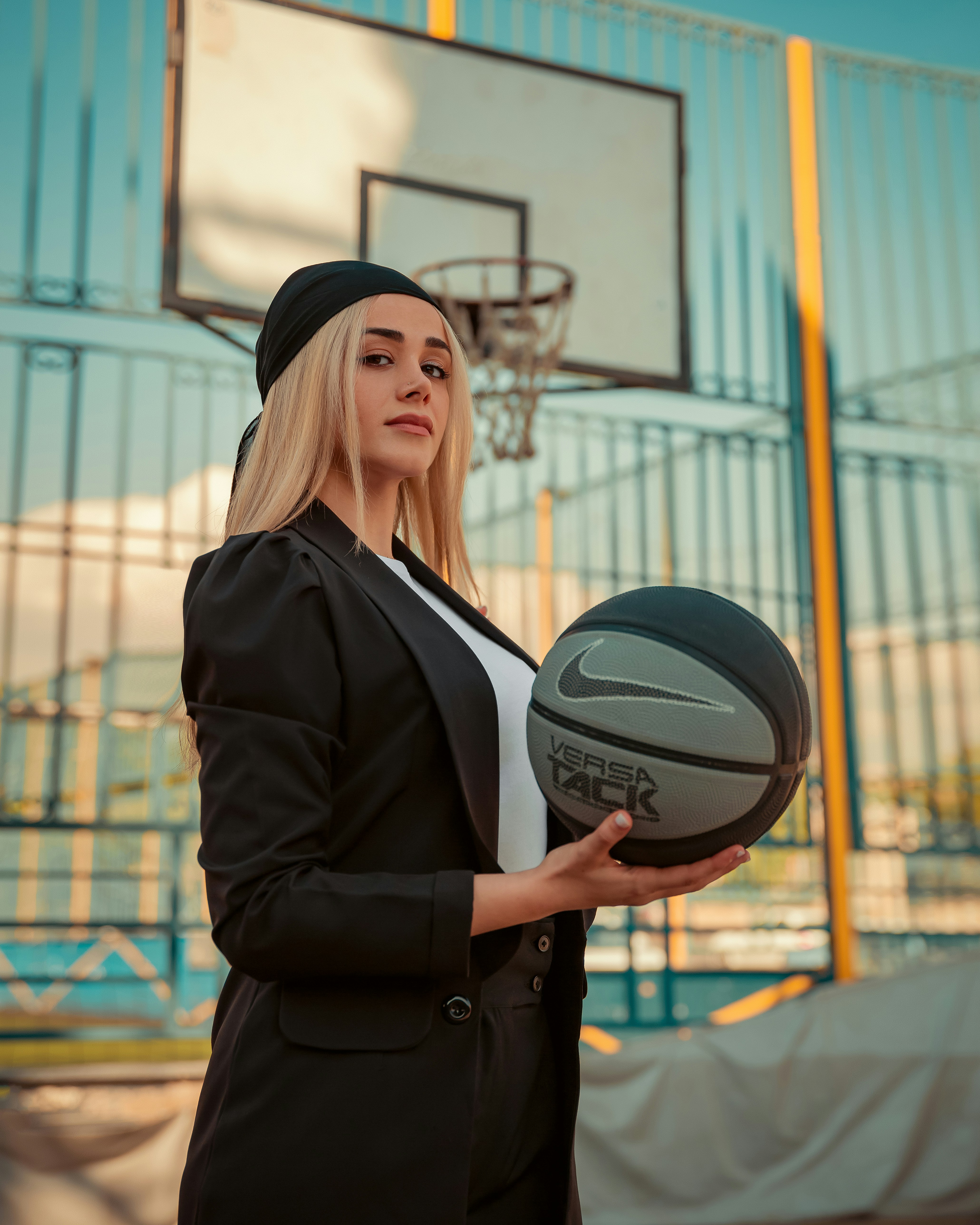 Belle femme tient un ballon de basket sur le terrain.