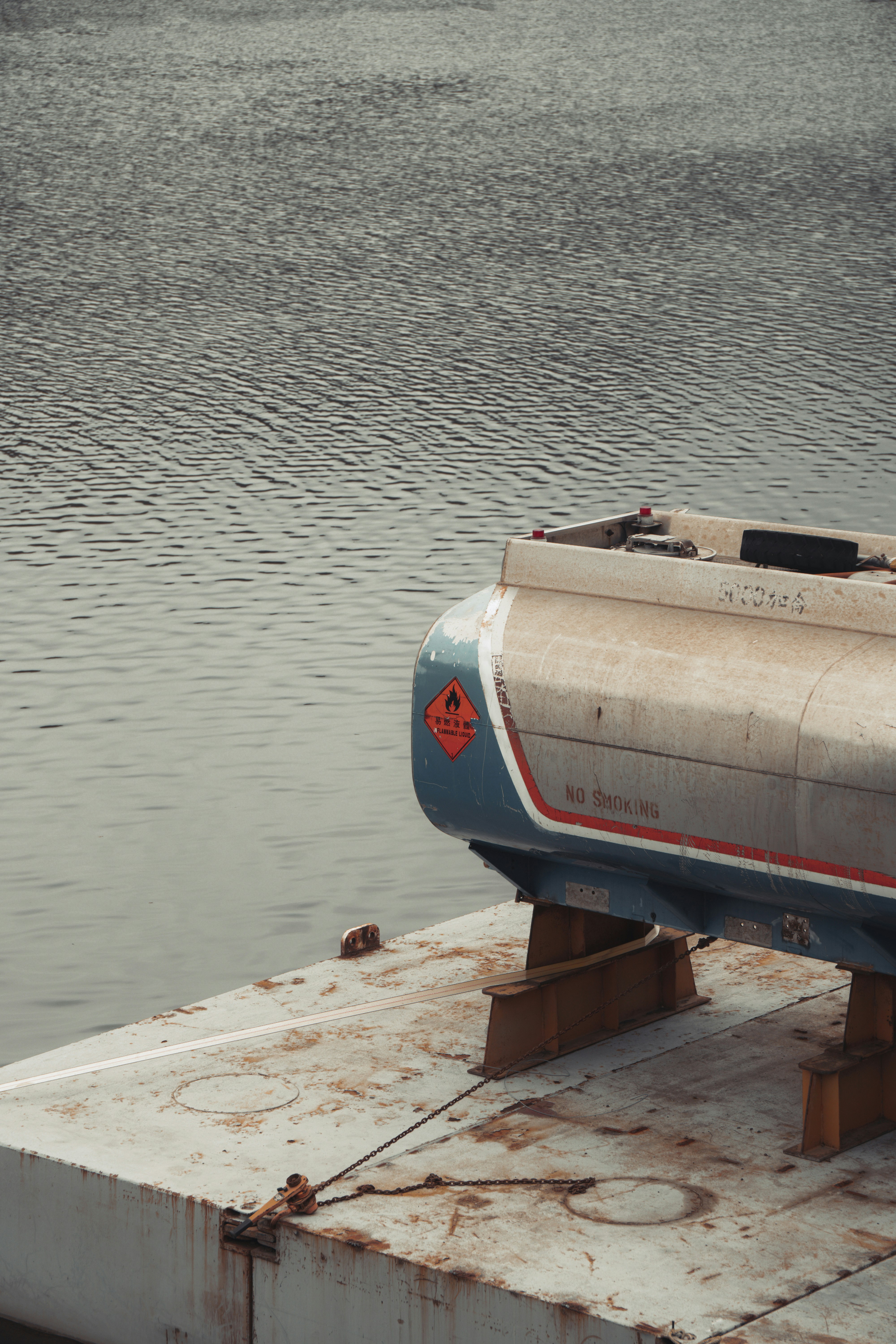 Un tanque de combustible descansa sobre una plataforma sobre el agua.