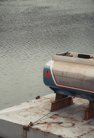 A fuel tank rests on a platform over water.