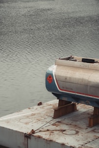 A fuel tank rests on a platform over water.