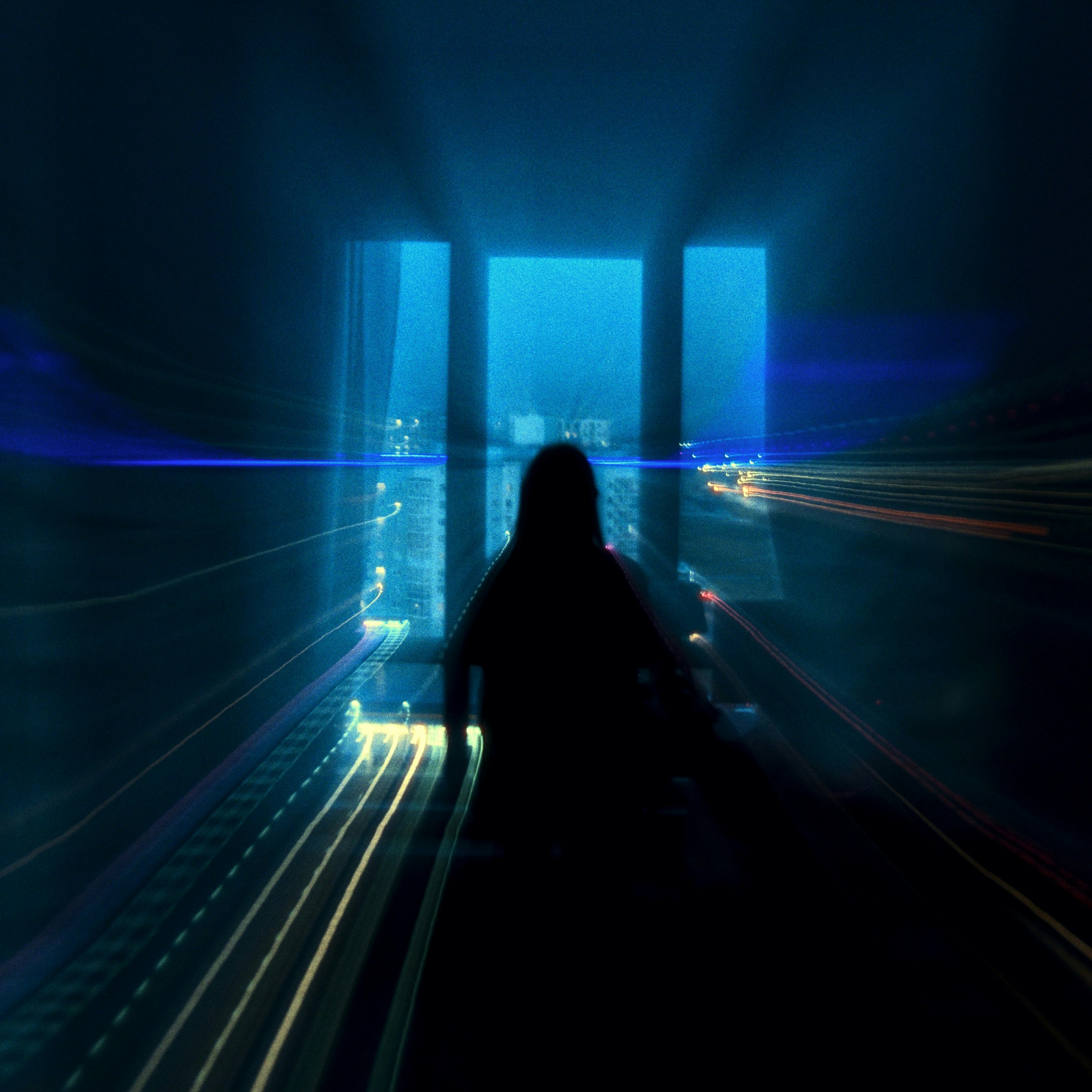 A silhouette looks out the window at night.