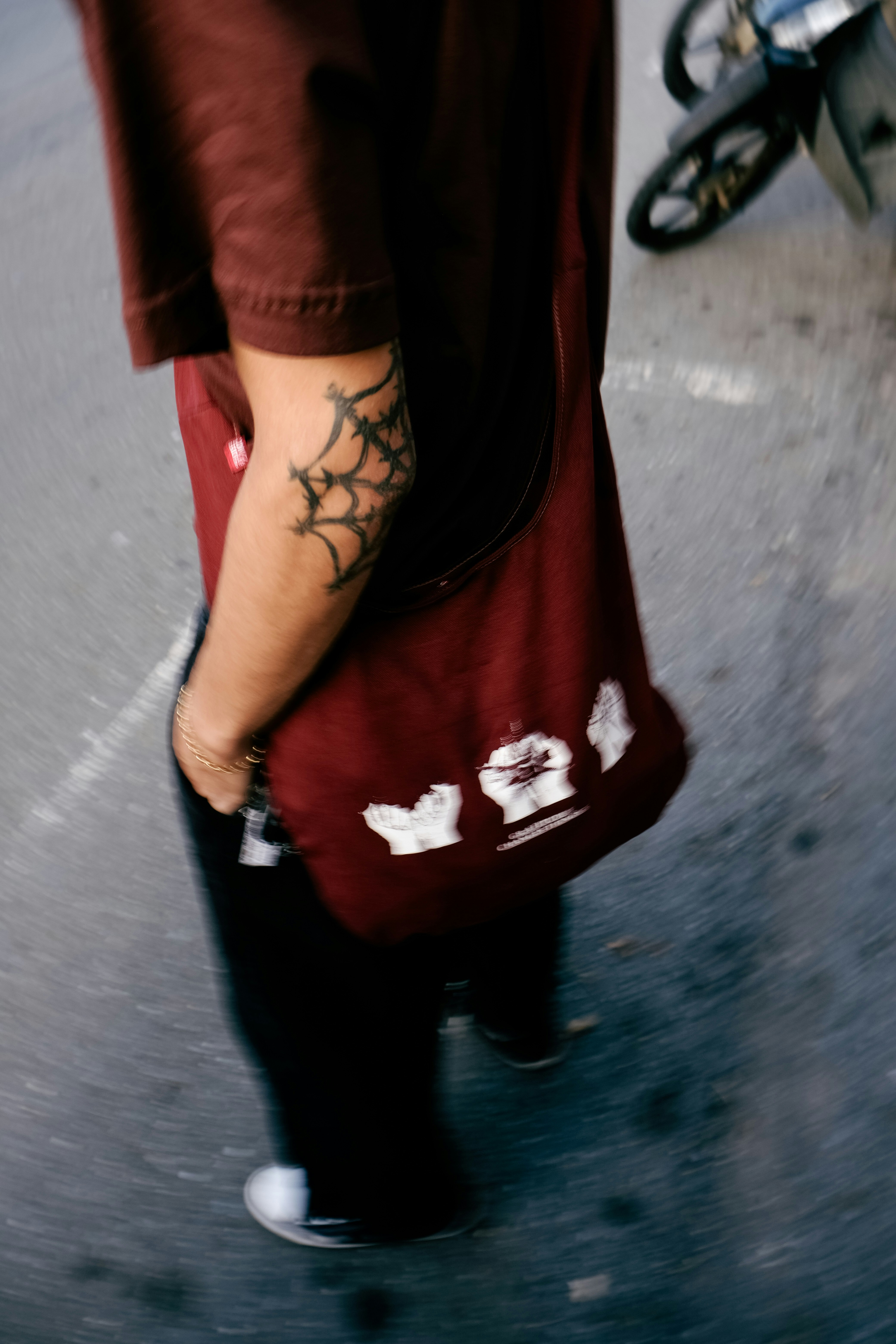 Une personne marche dans la rue avec un tatouage.