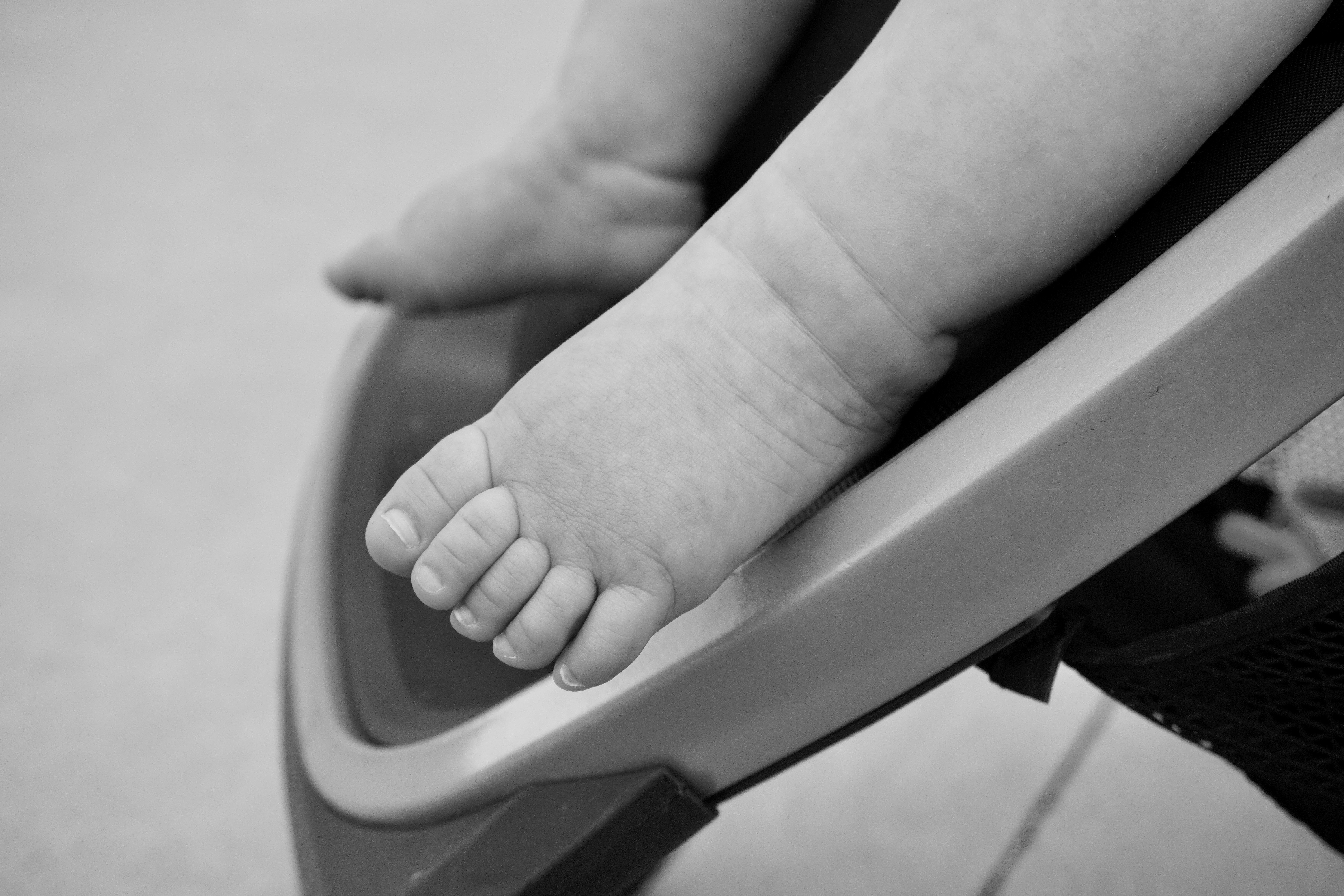 A baby's foot resting in a high chair.