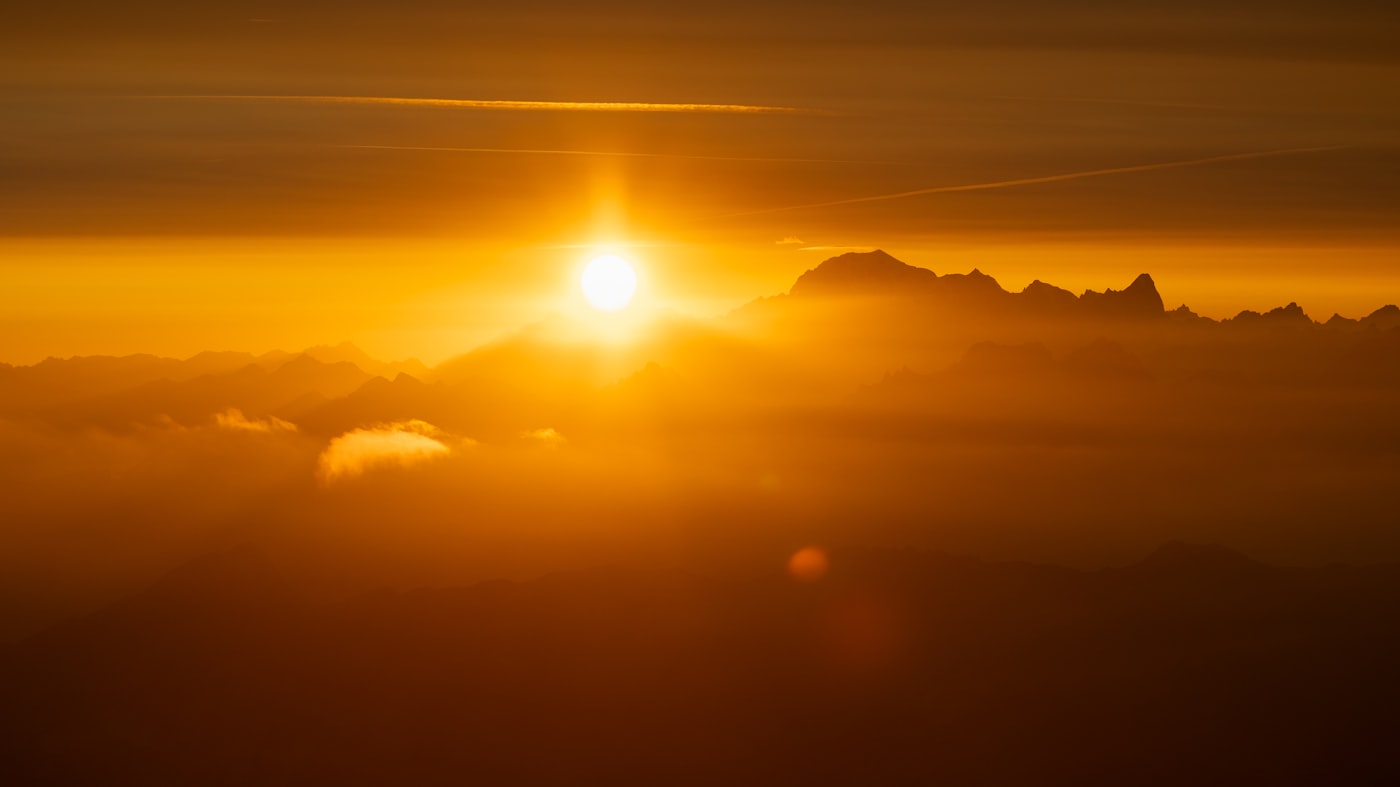Sun cresting above a sea of golden clouds — divine design