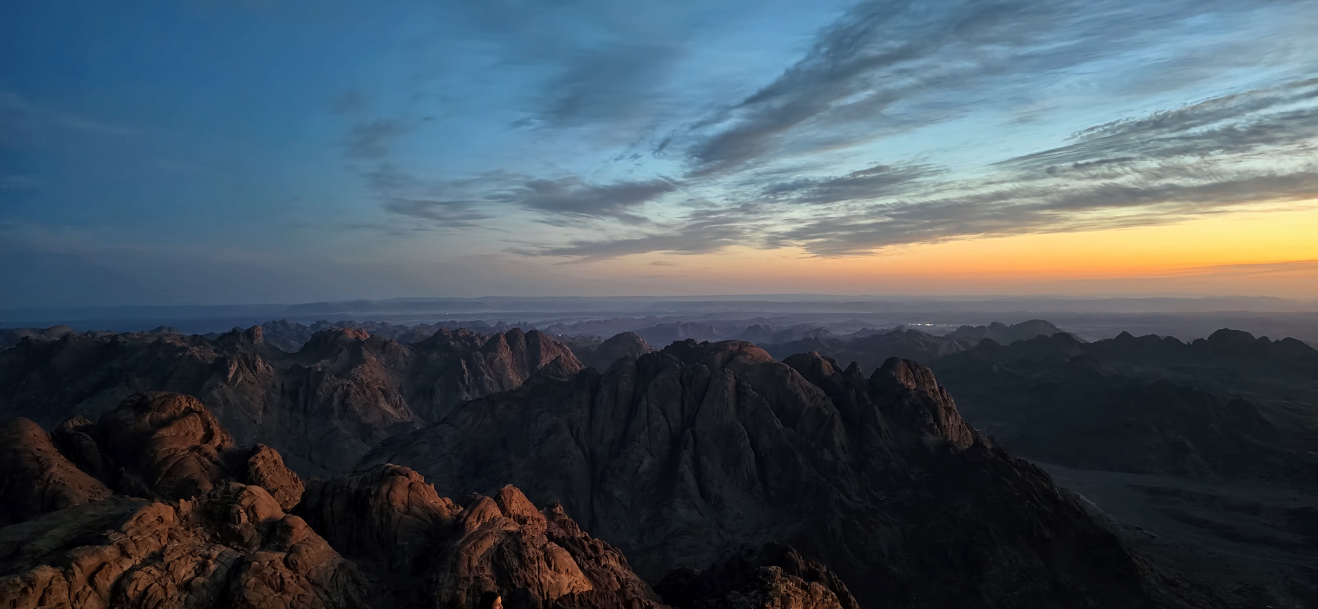 Mountains under a colorful sky at sunset.