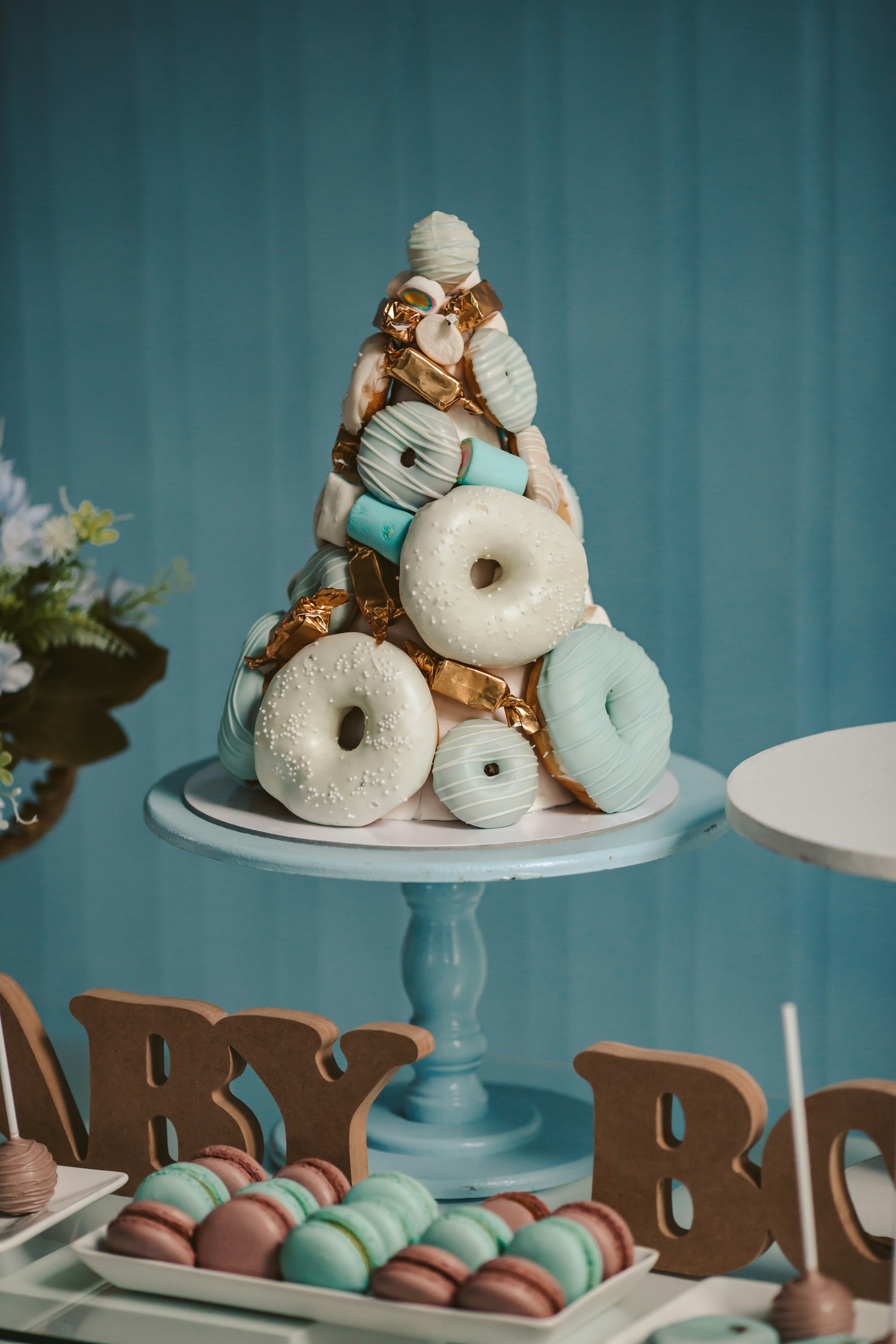 A donut cake stands tall on a blue table.