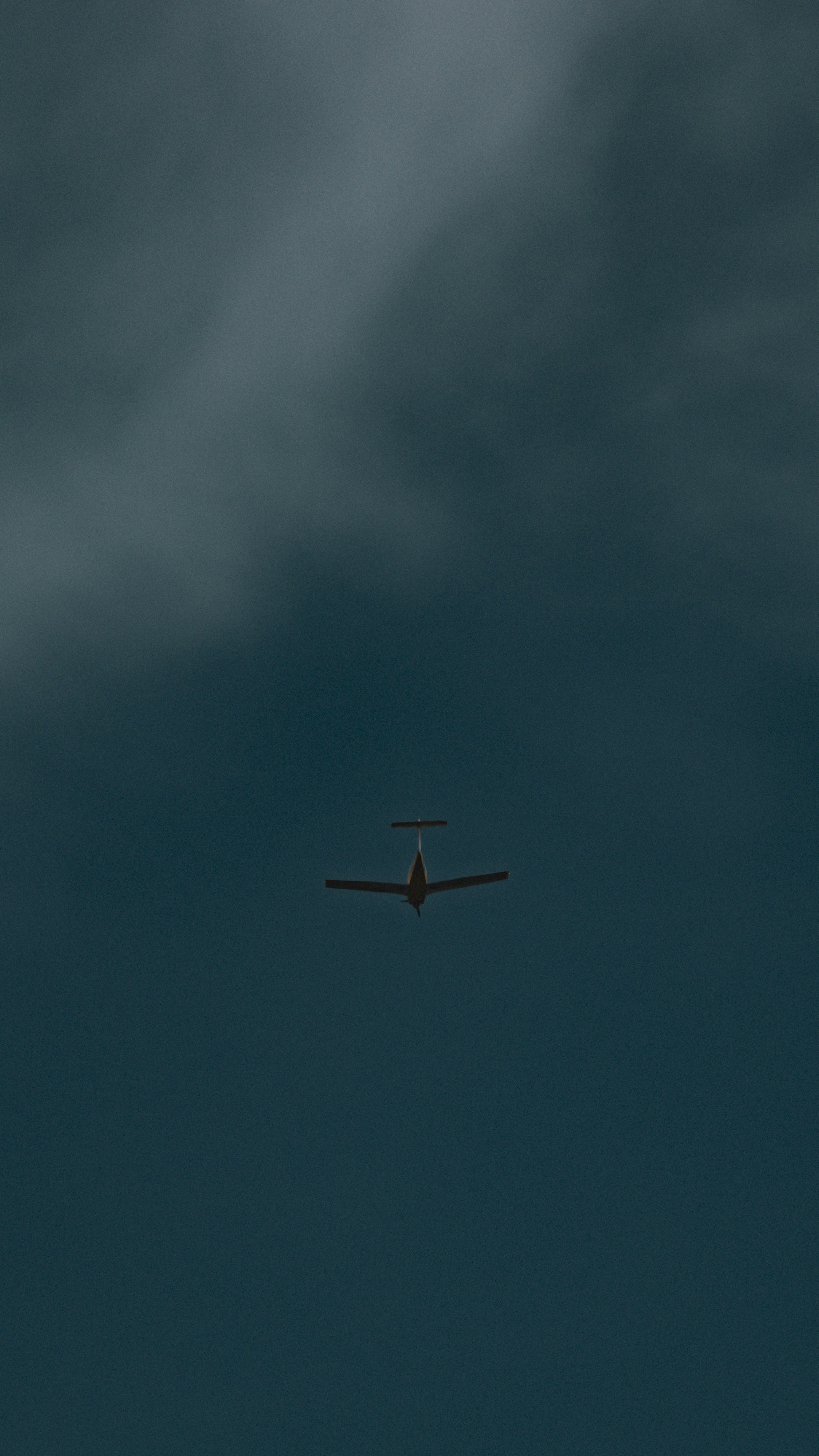 An airplane soars through the dark sky.