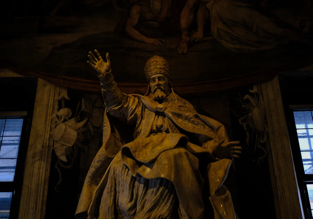 Statue of a robed figure with raised hand.