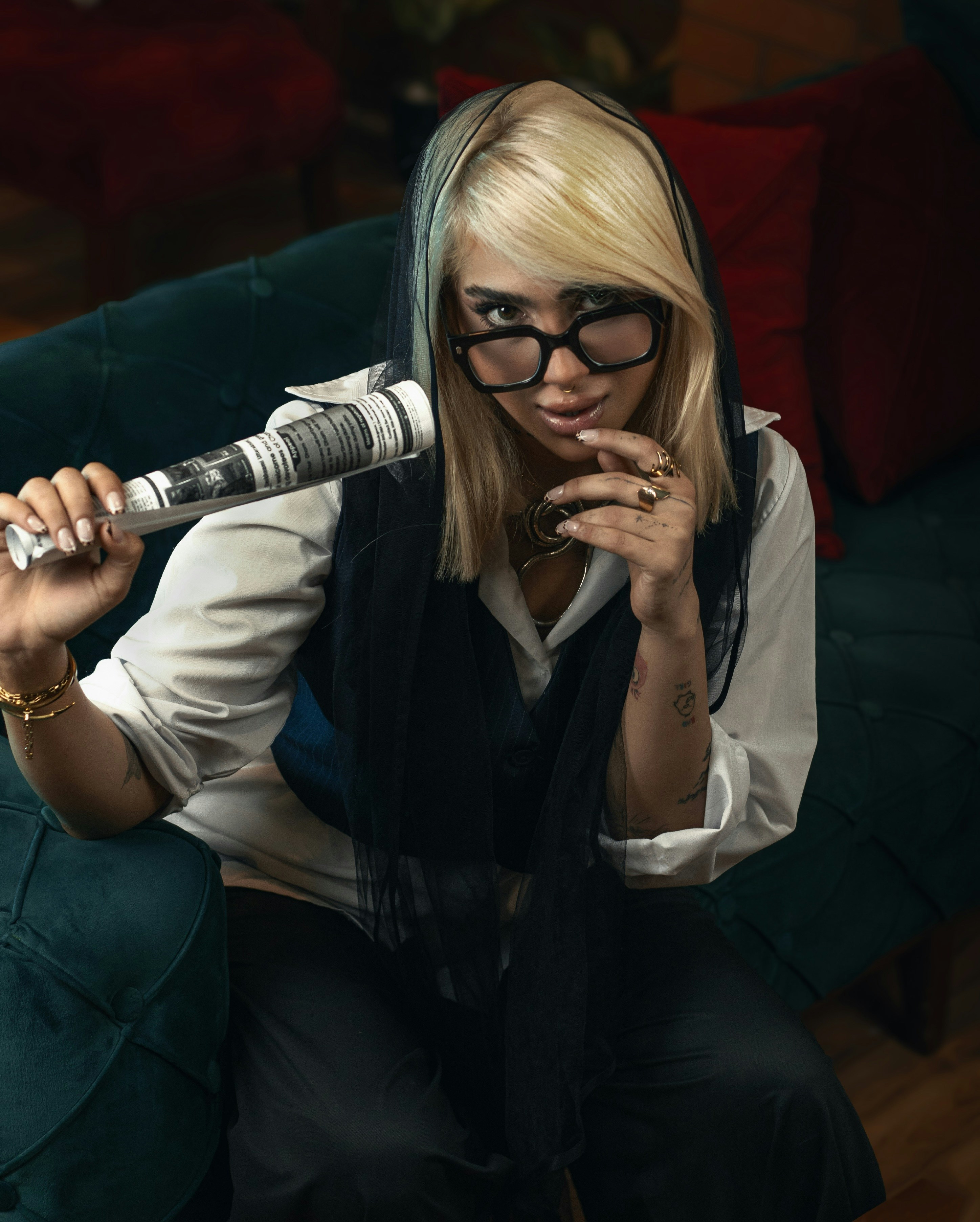 Woman with glasses and a rolled up newspaper.