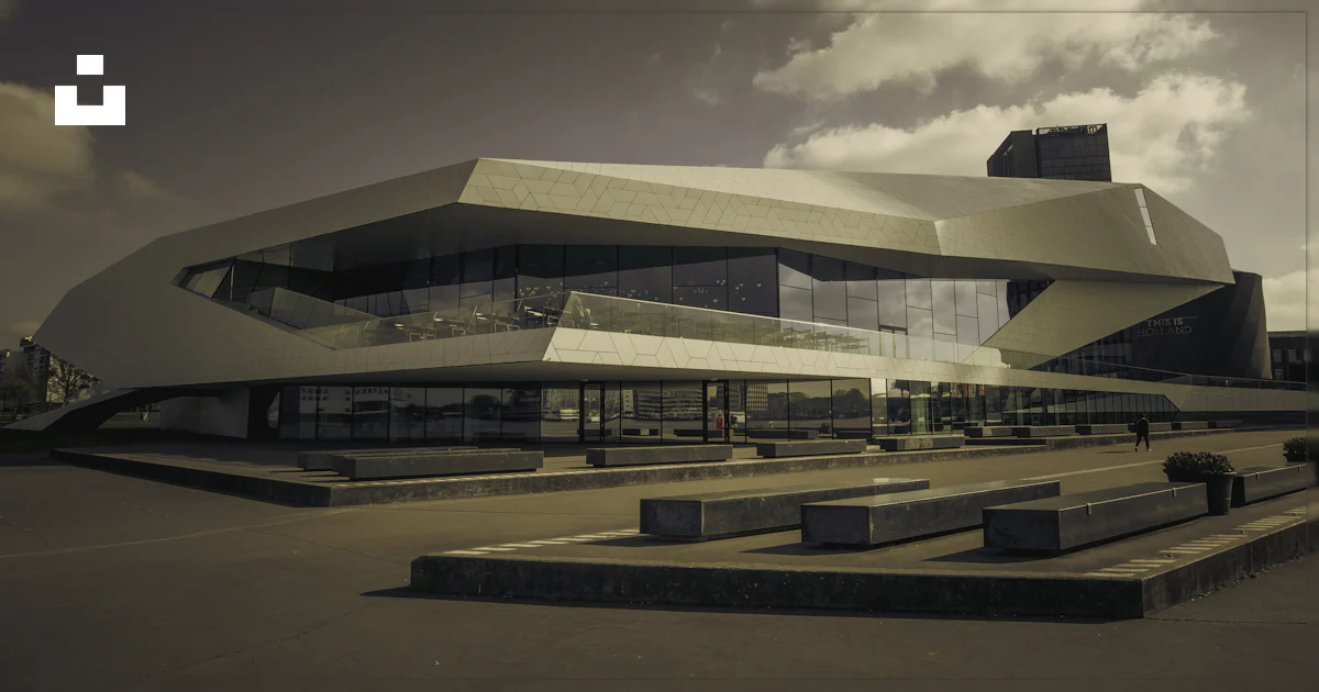A modern, angular building stands prominently. photo – Free Building ...