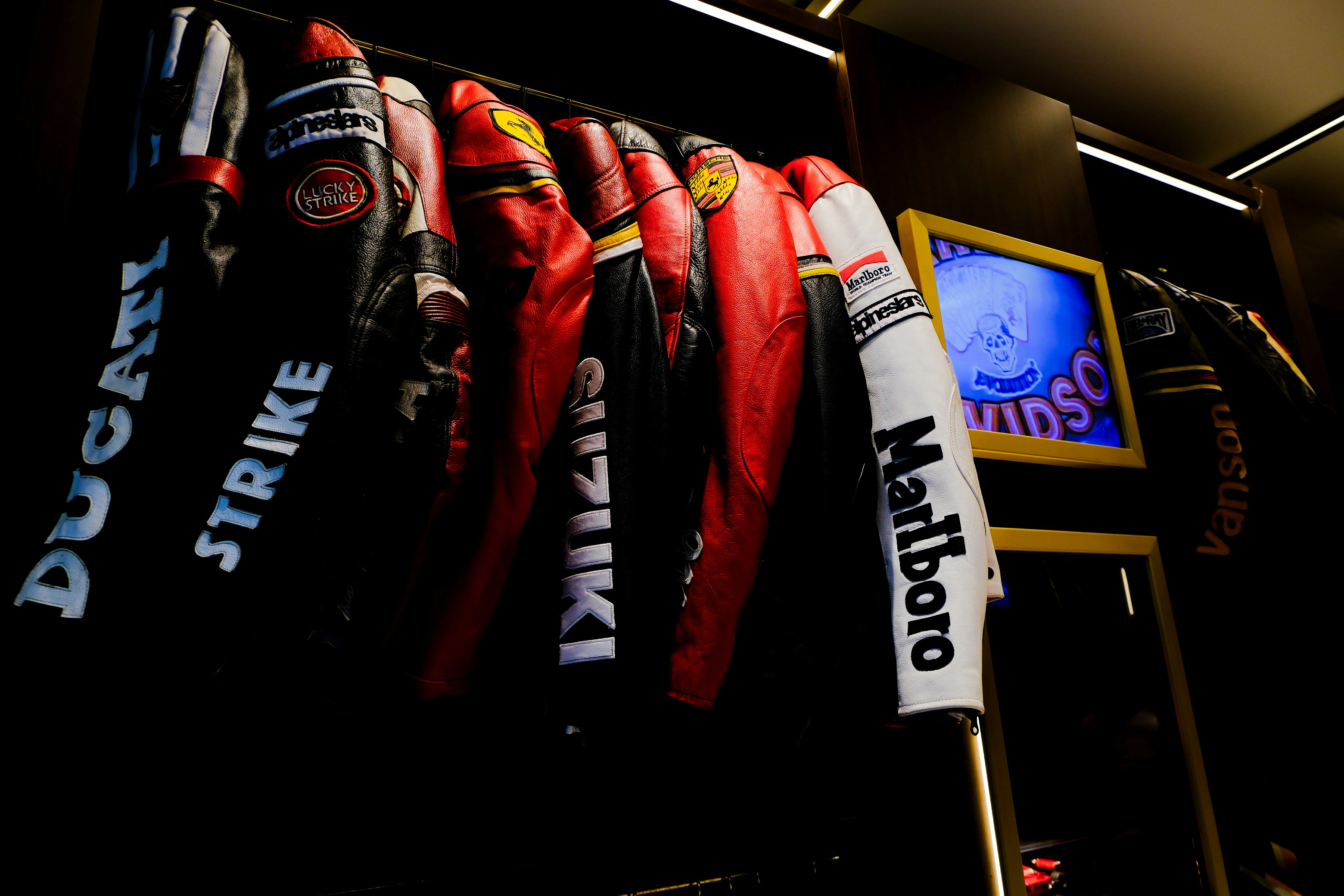 Motorcycle jackets are displayed on a rack.