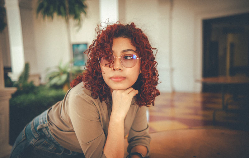 curvy woman with curly hair posing thoughtfully
