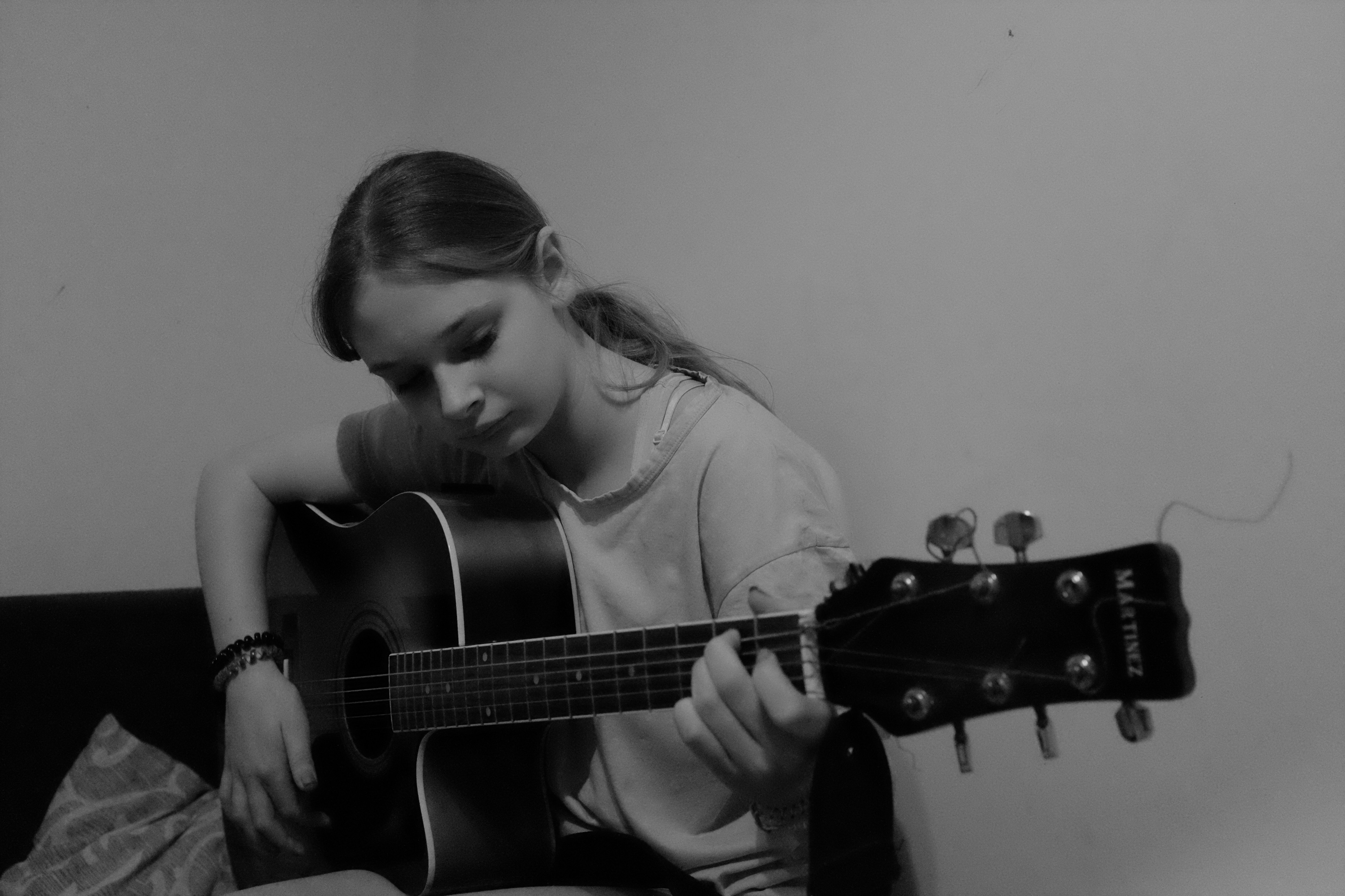 A young girl plays an acoustic guitar.