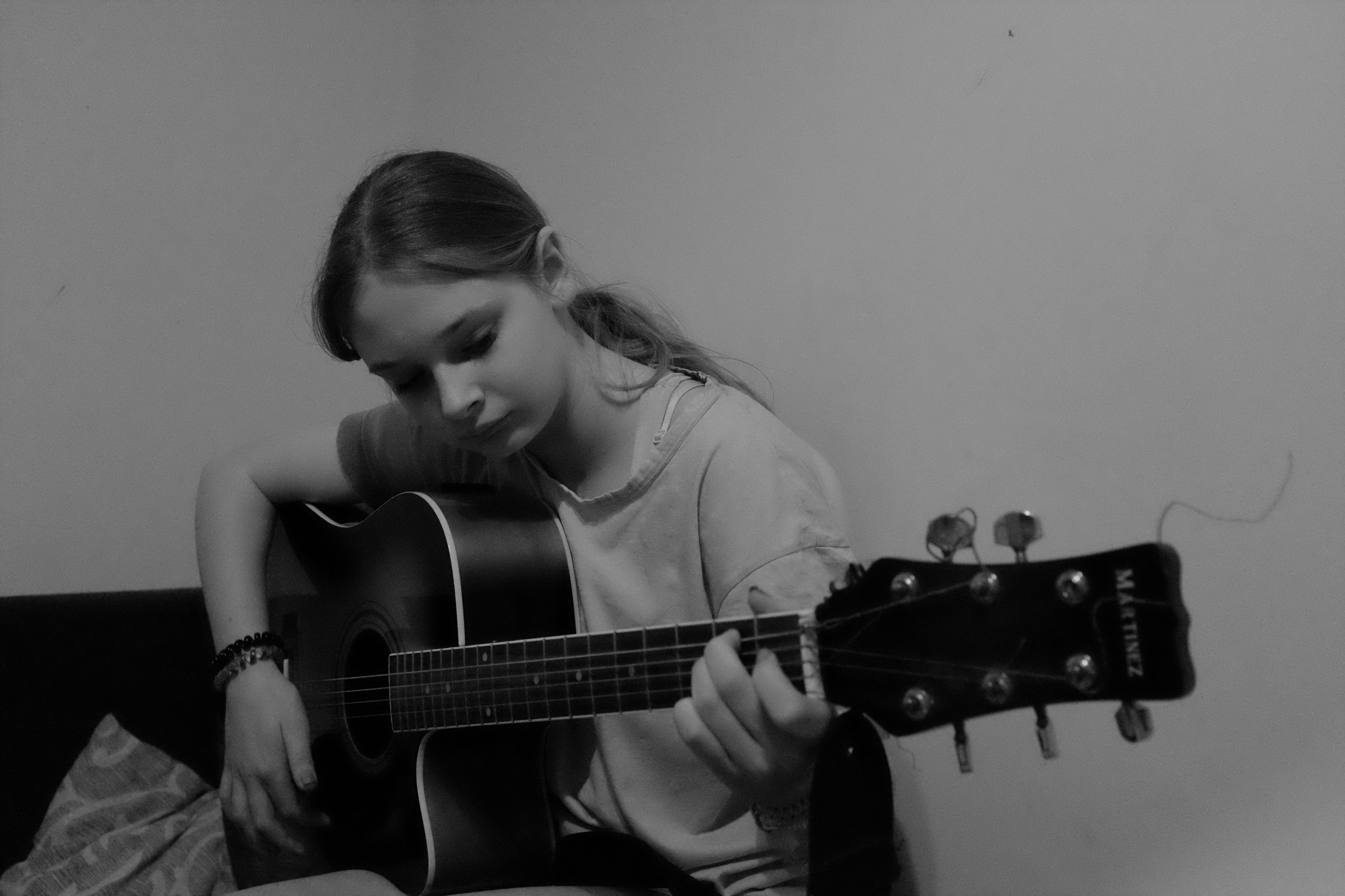 Une jeune fille joue de la guitare acoustique.