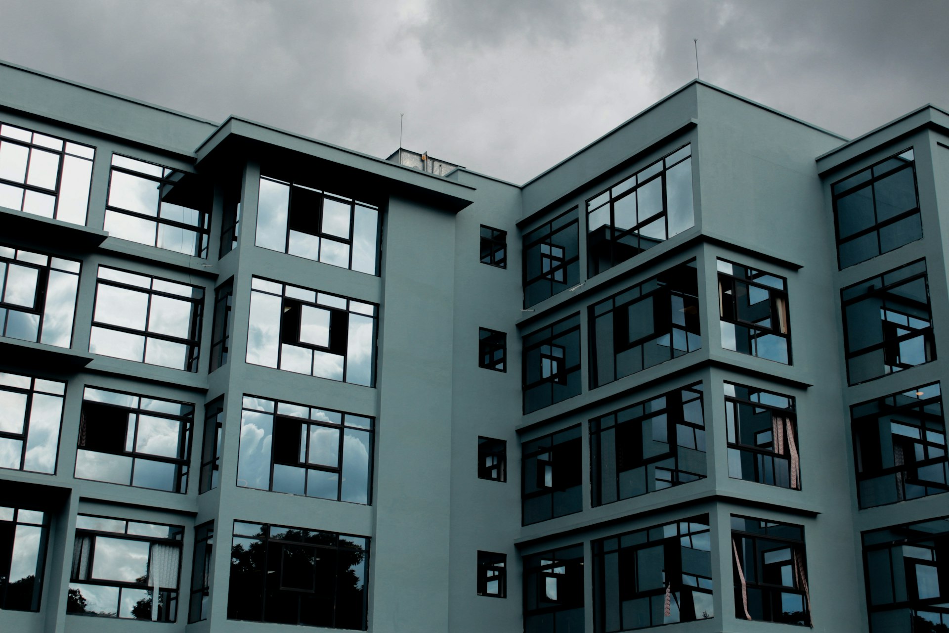 Modern residential building standing out against a dark and stormy sky illustrating the rainy season