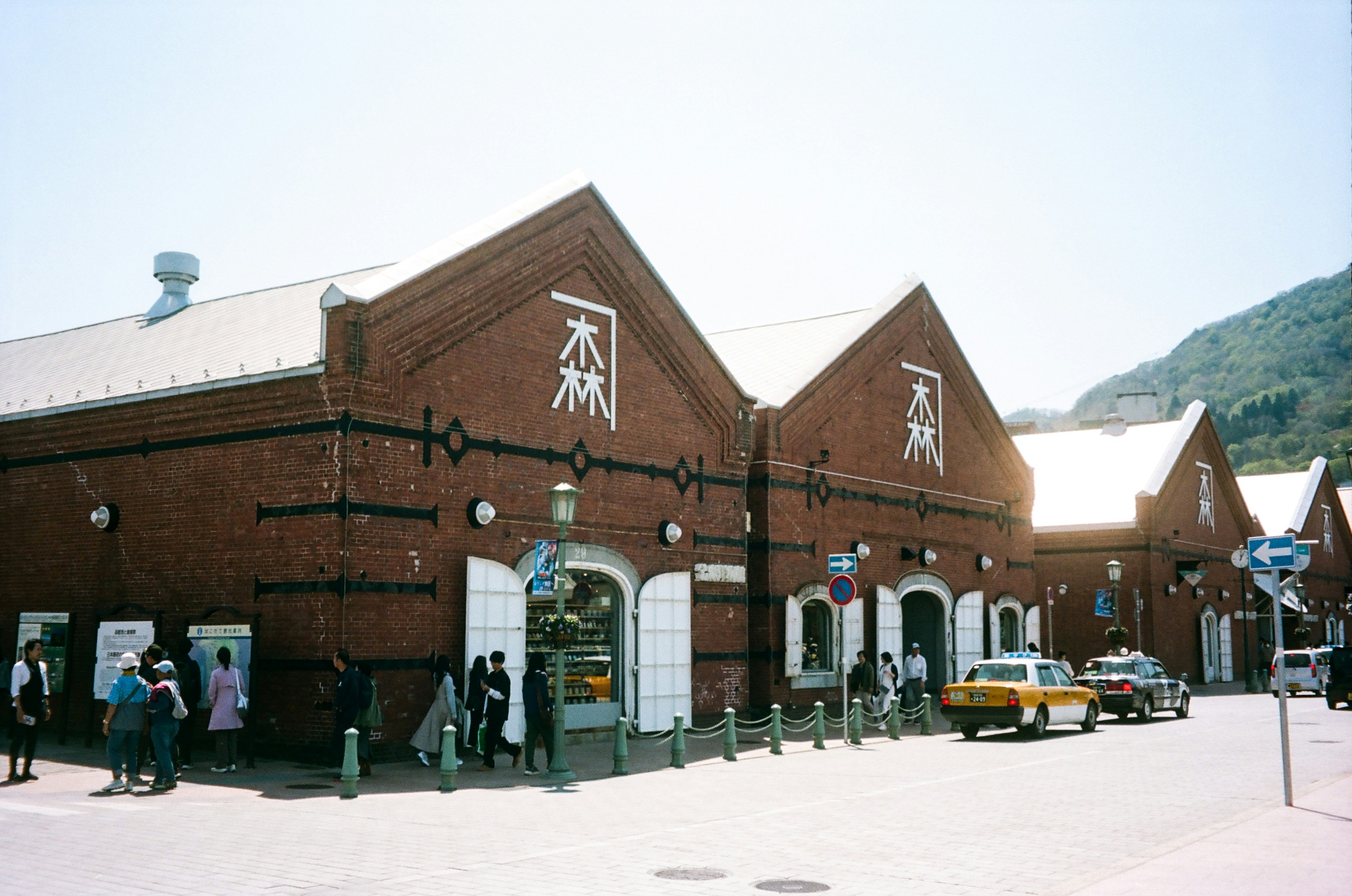Red brick warehouses with people and cars.