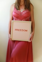 Woman holds sign that reads "freedom."