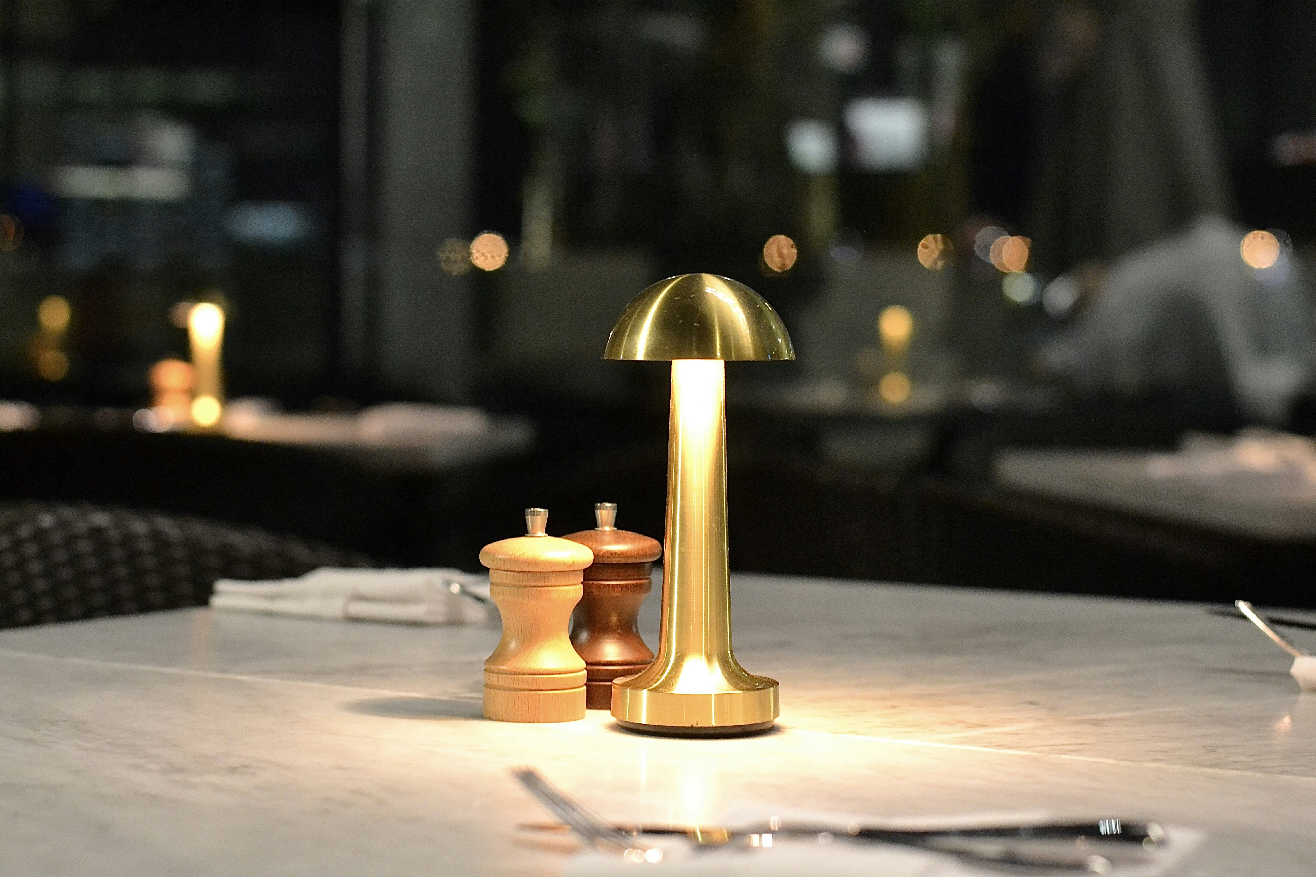 A golden lamp lights up a restaurant table