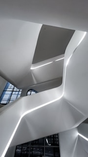 Modern architecture with white curves and integrated lighting.