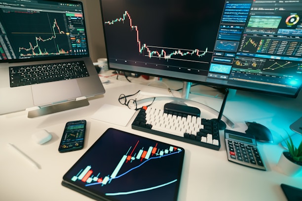 Stock charts are displayed on multiple screens.