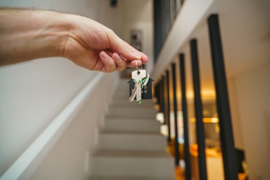 Here's a possible caption: keys being held in front of a staircase.