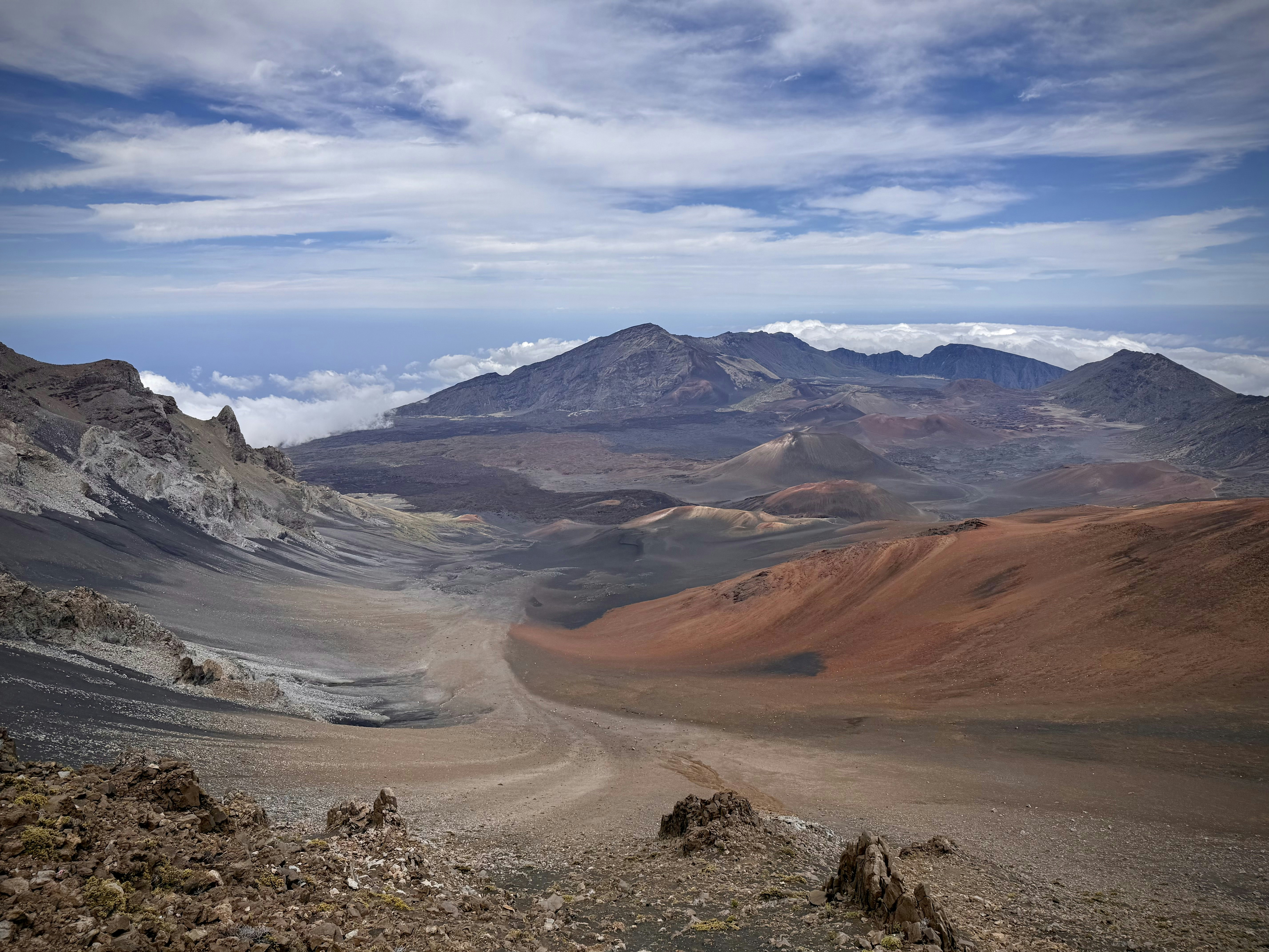 Vast, colorful valley with distant mountains and blue sky.