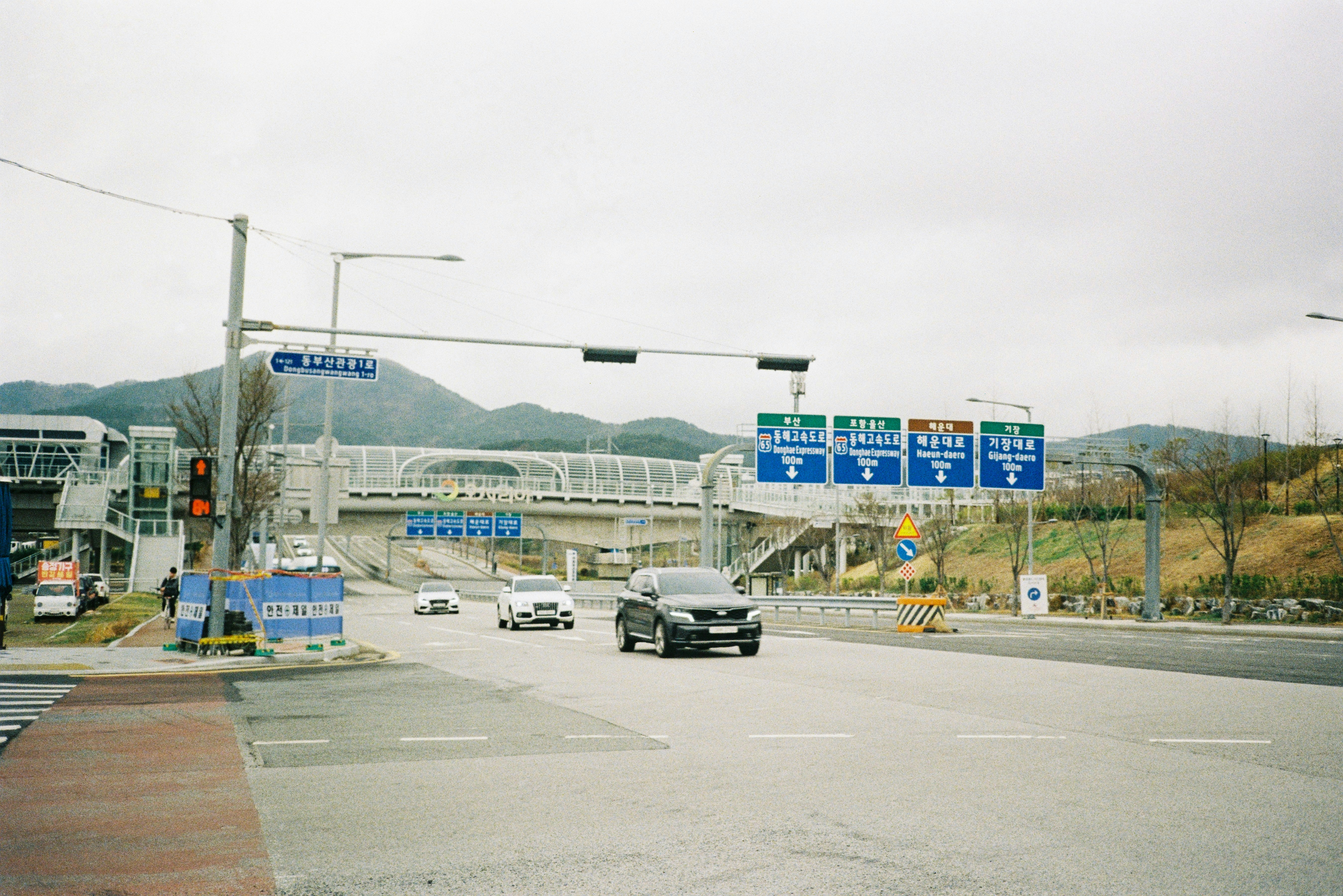 Cars travel down a road with signs.