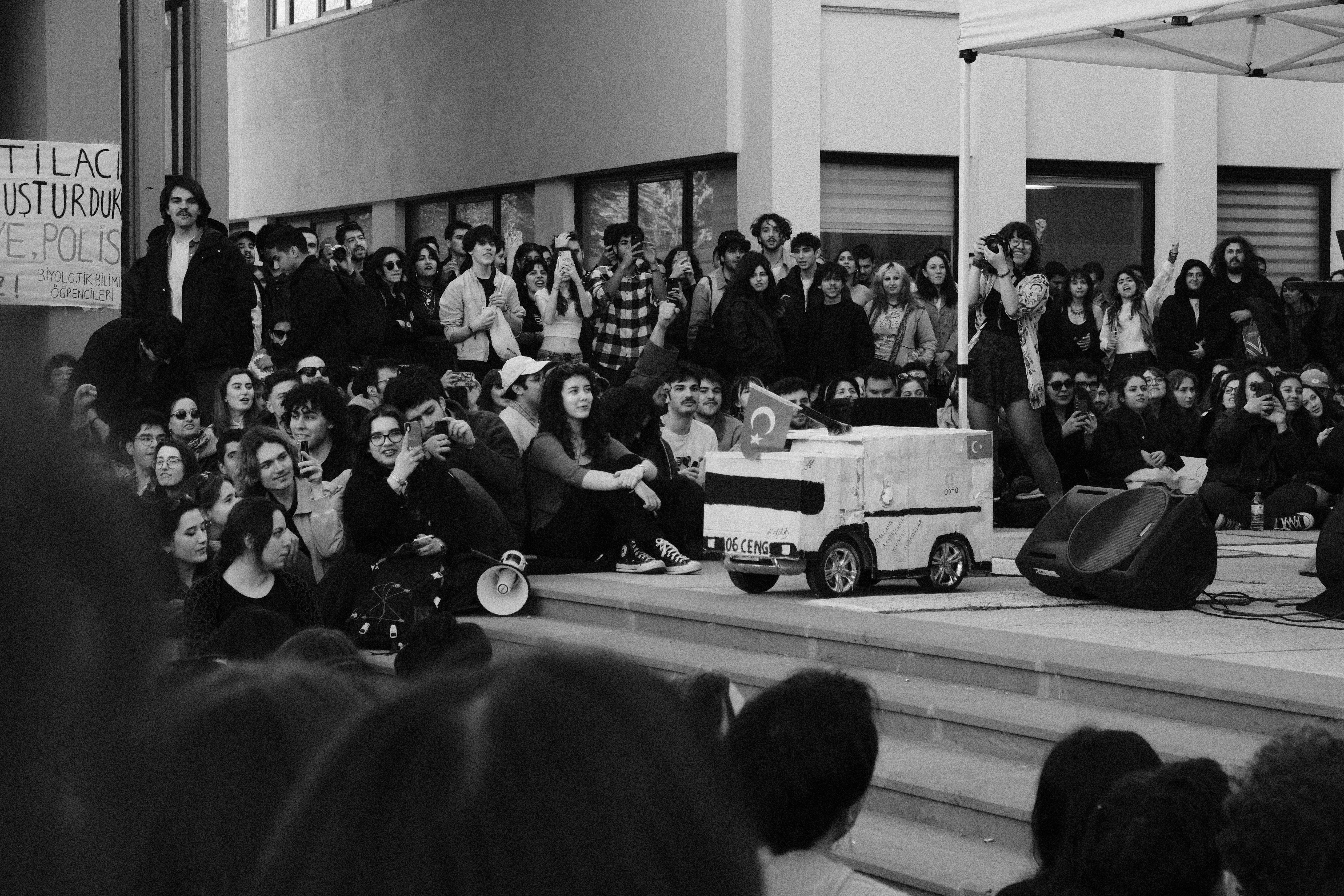 Students gather around a small robot for a presentation.