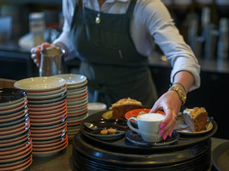 A waitress serves cake and coffee.