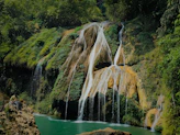 A beautiful waterfall flows amidst lush greenery.