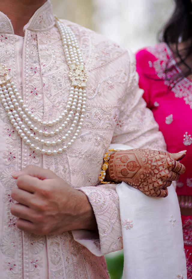 Bride and groom hands with traditional mehendi and jewellery