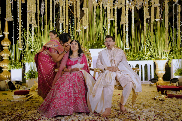 Couple and guest pose at an outdoor wedding.