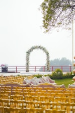 A wedding ceremony setup with floral arch and seating.