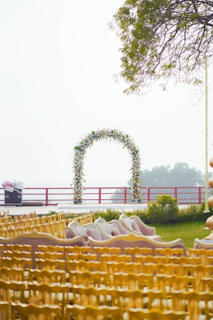 A wedding ceremony setup with floral arch and seating.
